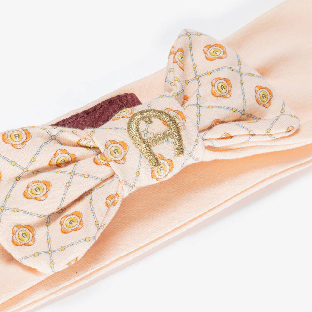 AIGNER-Baby Girls Peach Pink Bow Headband with Gold Logo Embroidery | Childrensalon