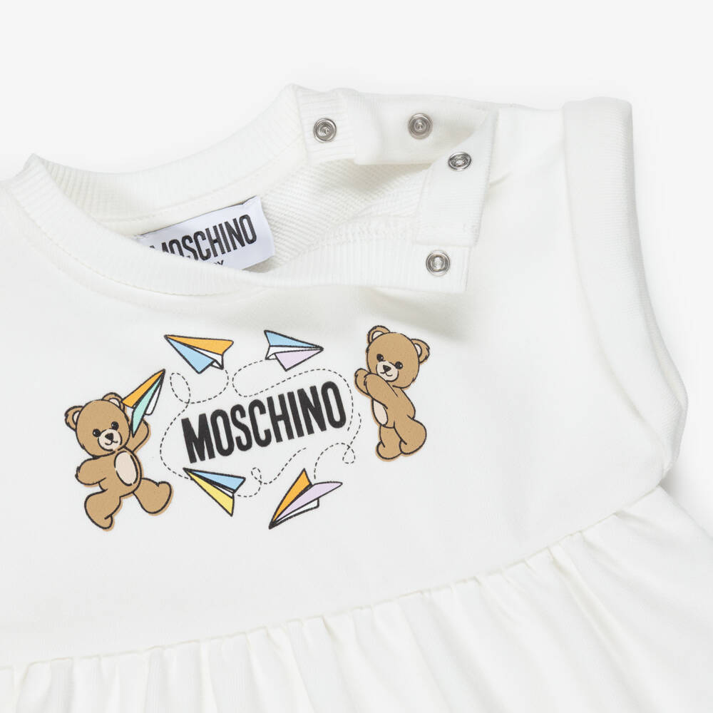 Moschino-Girls Ivory Cotton Teddy Bear Logo Dress with Paper Airplanes  | Childrensalon
