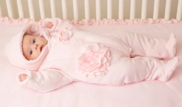 Baby boy dressed in a baby pramsuit.