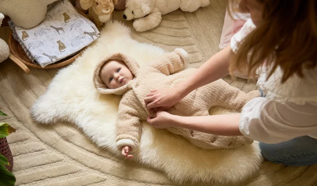 Baby boy dressed in a baby pramsuit.