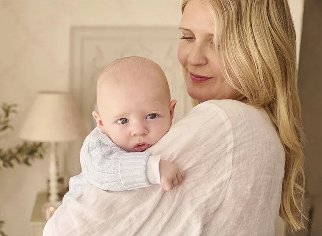 A baby girl sleeping in a floral matching babgrow and hat.